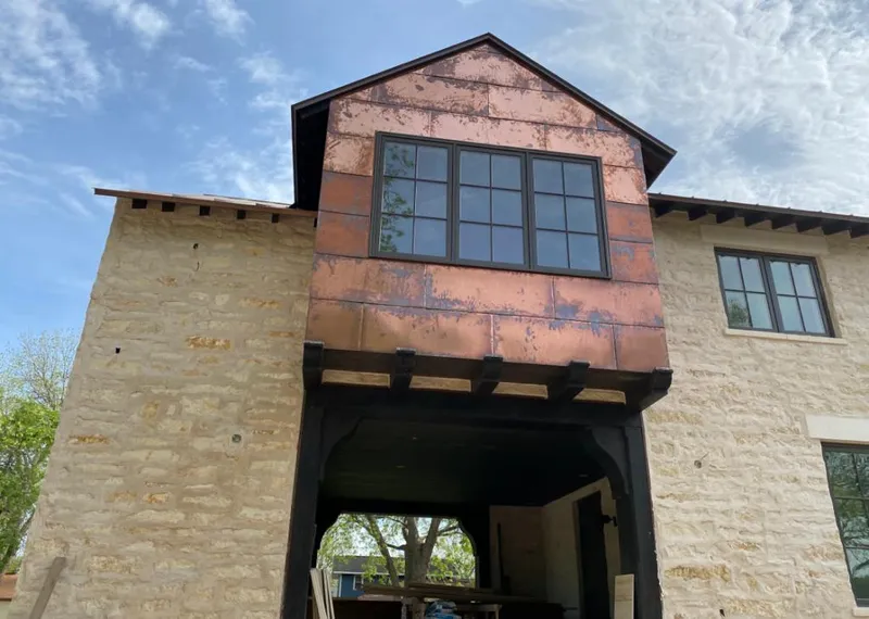Copper metal panel facade on a stone building for Roof Repair in Charlotte